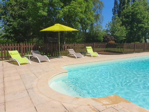 a group of chairs and an umbrella next to a swimming pool at Le Grand Domaine du Rocher in Bonnemain