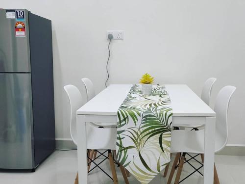 mesa blanca con sillas blancas y nevera en Homestay KLIA Core Soho Suites, en Sepang