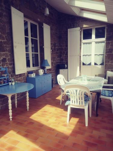 - une salle à manger avec deux tables, une table et des chaises dans l'établissement Maison Du Tertre, à Lonlay-lʼAbbaye