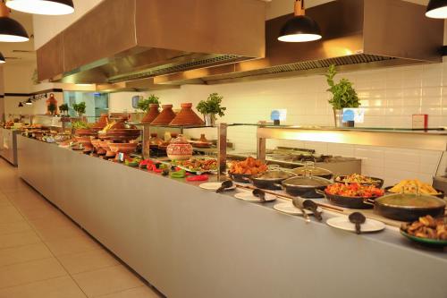 a kitchen with many plates of food on a counter at Radisson Blu Resort Taghazout Bay Surf Village in Taghazout