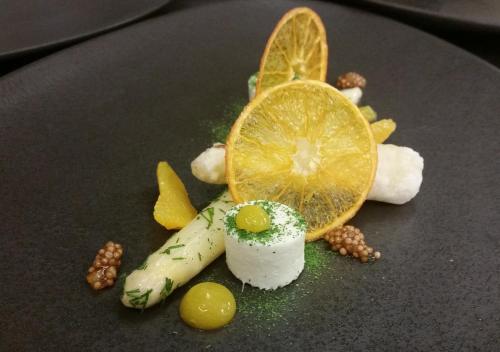a dessert with an orange slice on a black plate at Romantik Alpenhotel Waxenstein in Grainau