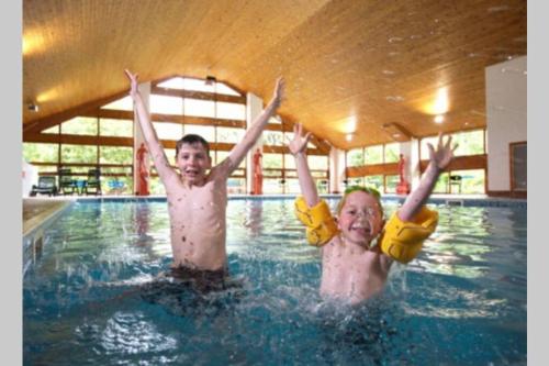three children swimming in a swimming pool at Mistletoe One Luxury Lodge with Hot Tub Windermere in Windermere