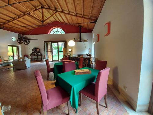 a dining room with a green table and pink chairs at Chiosi Country Club in Corleone