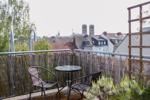 a patio with two chairs and a table on a balcony at Hotel Pilar Garni in Cologne