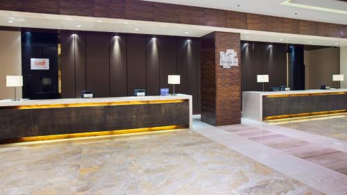 a lobby with a reception desk in a hotel at Holiday Inn Mudanjiang by IHG in Mudanjiang