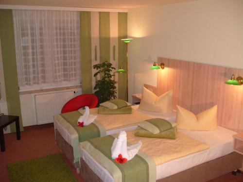 a hotel room with two beds with swans on them at Hotel Haufe in Forst