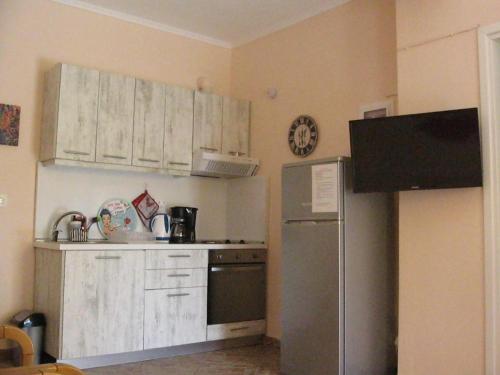 a kitchen with white cabinets and a stainless steel refrigerator at Ground beach studio in Nea Potidaea