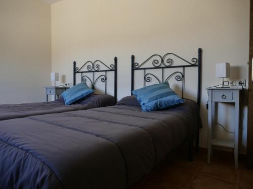 セエヒンにあるCasa Rural Ortega Rubioのベッド2台(隣同士に青い枕付)