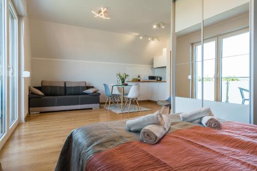 a bedroom with a large bed and a living room at Verde House in Karwia