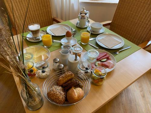 a table with breakfast foods and drinks on it at Hotel Garni Dünennest in Sankt Peter-Ording