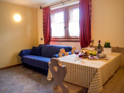 a living room with a table and a blue couch at Residence Pedranzini in Bormio