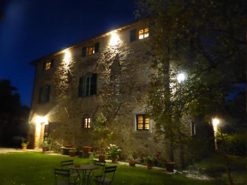 a large stone building with lights on it at night at Country House La Casa Paterna in Monte Santa Maria Tiberina
