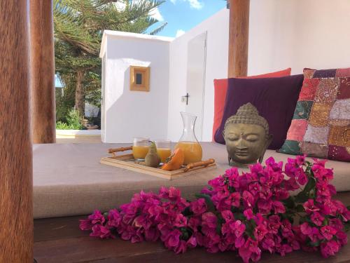 a bed with a statue of a head and flowers at Villa Roferos 32 in Puerto del Carmen