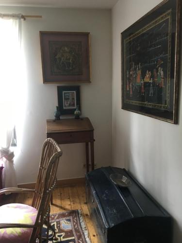 a living room with a table and a chair at B&B Le Moulin de Fernelmont in Forville