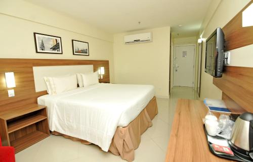 a hotel room with a bed and a television at Holiday Inn Express Belem Ananindeua by IHG in Belém