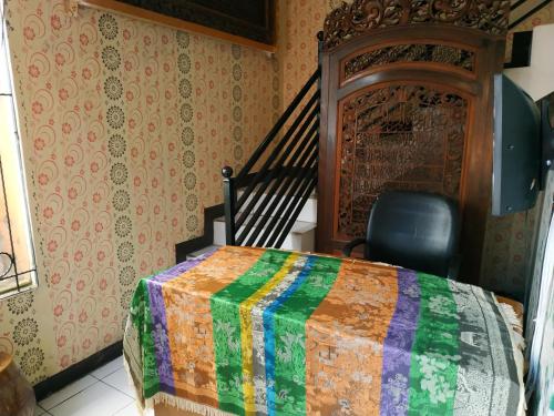 a bedroom with a bed with a colorful quilt at Pemda 22 Mansion Mitra RedDoorz in Bogor