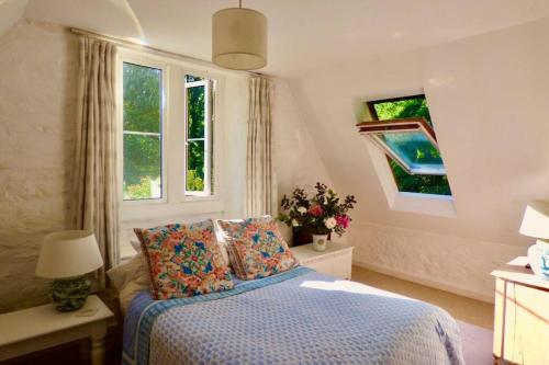 a bedroom with a bed and a window at Beautiful converted Stable in peaceful Somerset, close to the Jurassic Coast in Chard