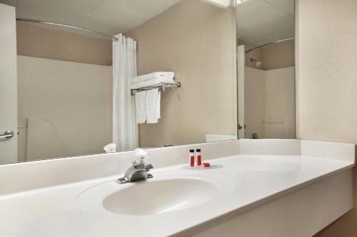 a white bathroom with a sink and a mirror at Super 8 by Wyndham Cherokee in Cherokee