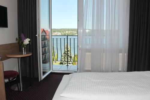 a hotel room with a bed and a balcony at Hotel Huszcza in Mrągowo