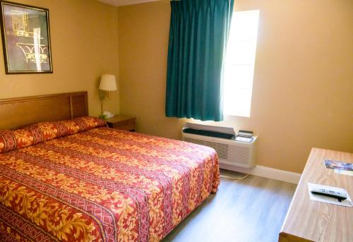 a hotel room with a bed and a window at Kings Inn Hot Springs in Hot Springs