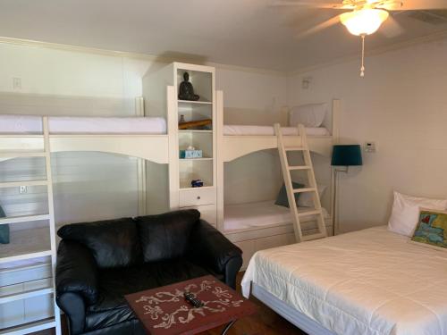 1 dormitorio con cama, sofá y literas en Backyard Cottage, en Lafayette