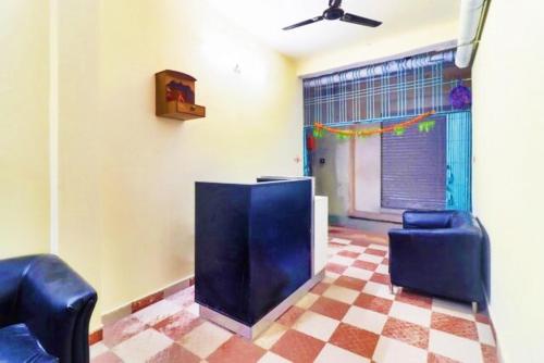 a room with two blue chairs and a checkered floor at Hotel Station View Mughalsarai by ShriGo Hotels in Mughal Sarāi