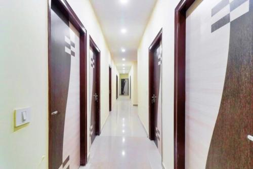 a corridor in a building with wooden doors at Hotel Station View Mughalsarai by ShriGo Hotels in Mughal Sarāi