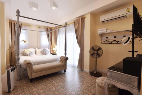 a bedroom with a canopy bed and a fan at Noursabah Boutique Bed Bangkok in Bangkok