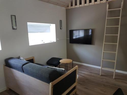a living room with a couch and a television at Small Paradise in Sørvágur