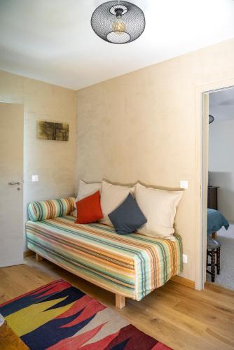 - un canapé avec des oreillers colorés dans l'établissement Chambre d'Hôtes chez Artiste Verrier, La Perrière - Perche, à La Perrière