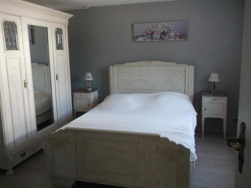 een slaapkamer met een wit bed en een spiegel bij Gite les Rosiers in Traubach-le-Bas