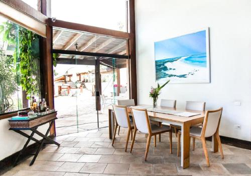 a dining room with a table and chairs at Monalisa Guesthouse Pé na Areia Ilhabela in Ilhabela