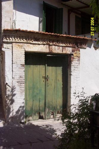 an old building with green doors on the side of it at Stou Kir Yianni in Omodos
