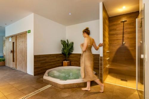 a woman walking in front of a bath tub at Houm Plaza Son Rigo in Playa de Palma