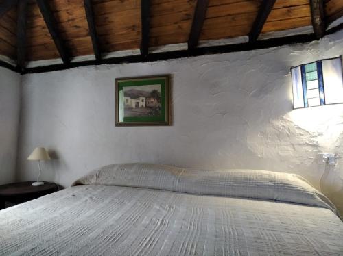 a bedroom with a bed in a white wall at I MITI ViviendaVacacional in Chio
