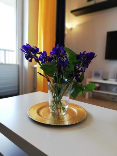 een vaas gevuld met paarse bloemen op een tafel bij Froja in Zator
