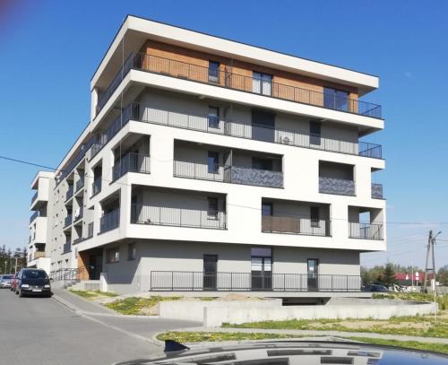 ザトルにあるFrojaのアパートメントビルの正面に車が停まっています。