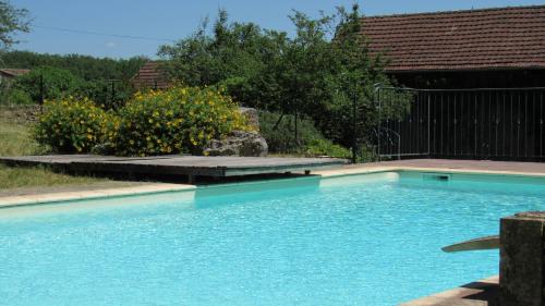 una piscina de agua azul en un patio en Chambres d'hôtes de la Grande Combe, en Mauzac-et-Grand-Castang