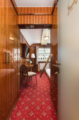 a corridor of a train room with a red carpet at Hôtel du Train in Munich