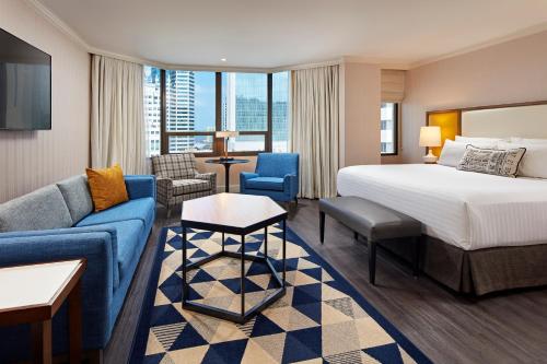 une chambre d'hôtel avec un lit et un canapé dans l'établissement The Bristol Hotel San Diego, à San Diego
