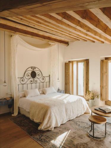 a bedroom with a large bed and a table at Mas Generós - Adults-Only Eco Hotel in Fonteta