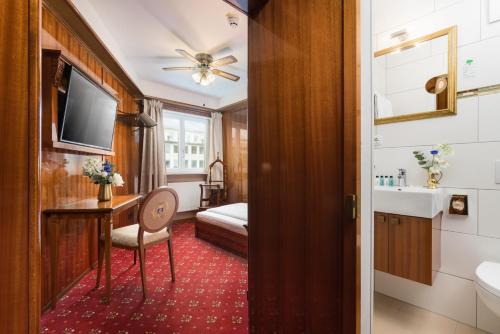 uma casa de banho com uma cama, um lavatório e um espelho. em Hôtel du Train em Munique