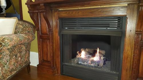 a fireplace with a fire in it next to a couch at Arbor View House Bed and Breakfast in East Marion