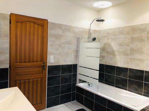 een badkamer met een bad, een wastafel en een spiegel bij Gîte San Jordi in Duilhac