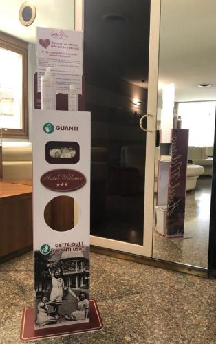 a sign in front of a glass door in a room at Albergo Milano in Boario Terme