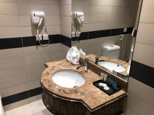 a bathroom with a wooden sink and two mirrors at اصال شقق فندقية فرع الحمراء in Jeddah
