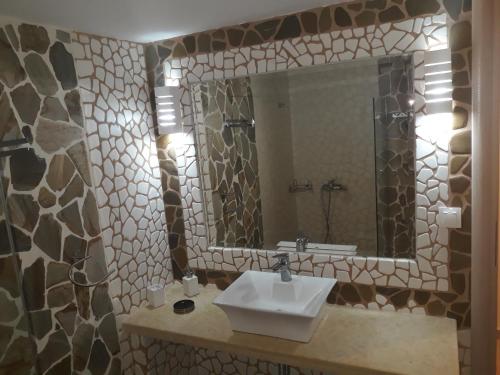 a bathroom with a sink and a mirror at Evdokia's Apartments and Rooms in Neos Marmaras