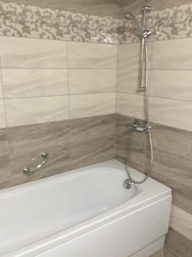 a white bath tub with a shower in a bathroom at Къща за гости Емона,Обзор in Obzor