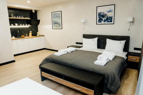 1 dormitorio con 1 cama grande y toallas. en Westhills Cottage Town & Spa en Bukovel