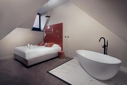 a white bath tub sitting next to a white toilet at The Anthony Hotel in Utrecht